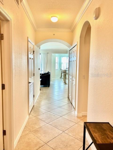 A hallway with tile flooring leads toward a living area with a view of windows — 16804 VARDON TERRACE UNIT 102, BRADENTON, FL