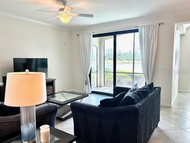 A living room features a dark sofa, a glass coffee table, and a view of a lake — 16804 VARDON TERRACE UNIT 102, BRADENTON, FL