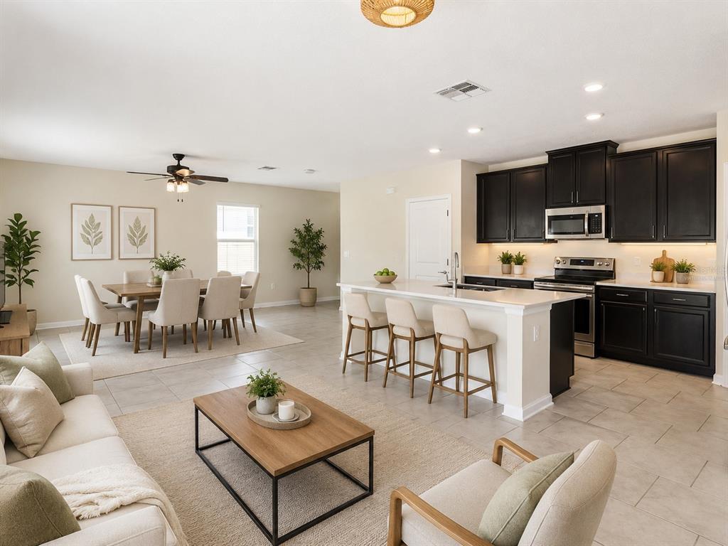 A kitchen with dark cabinets, white countertops, a center island, and a sliding glass door — 310 CITRUS POINTE DRIVE, DAVENPORT, FL