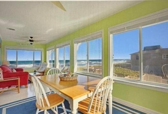 A sunroom with lime green walls, a dining table, and large windows overlooking the ocean — 1501 NE Ocean Boulevard # 2, Stuart FL 34996, STUART, FL