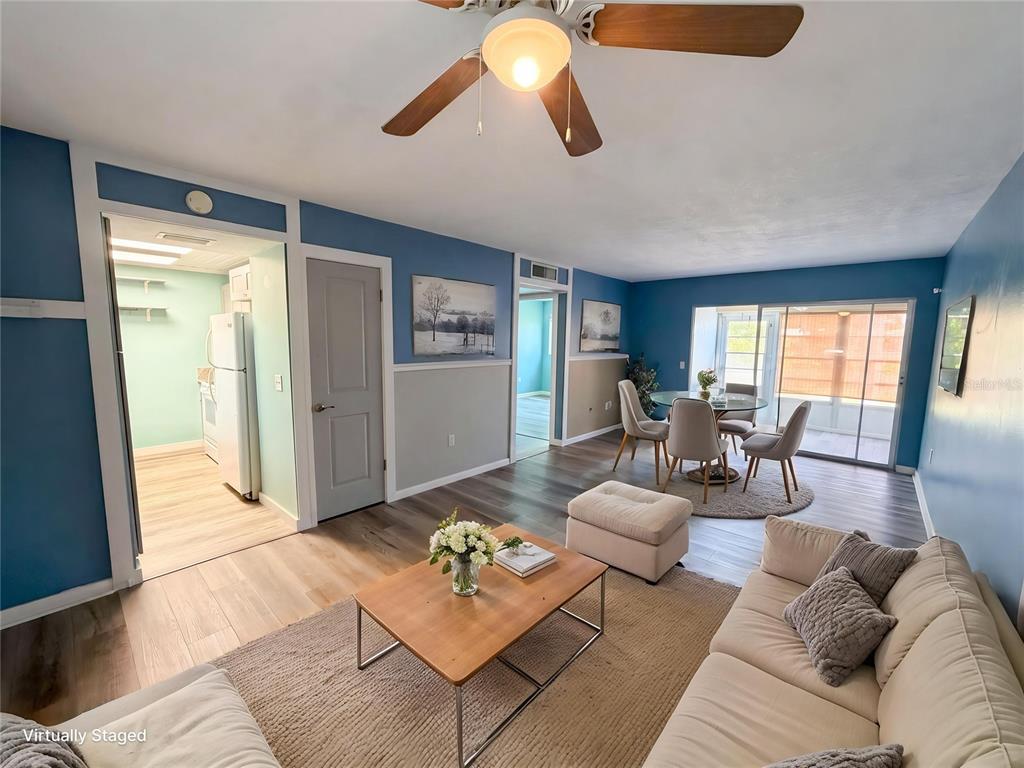 A living and dining area with blue walls, wood-look flooring, and a ceiling fan — 1303 S HERCULES AVENUE UNIT 6, CLEARWATER, FL