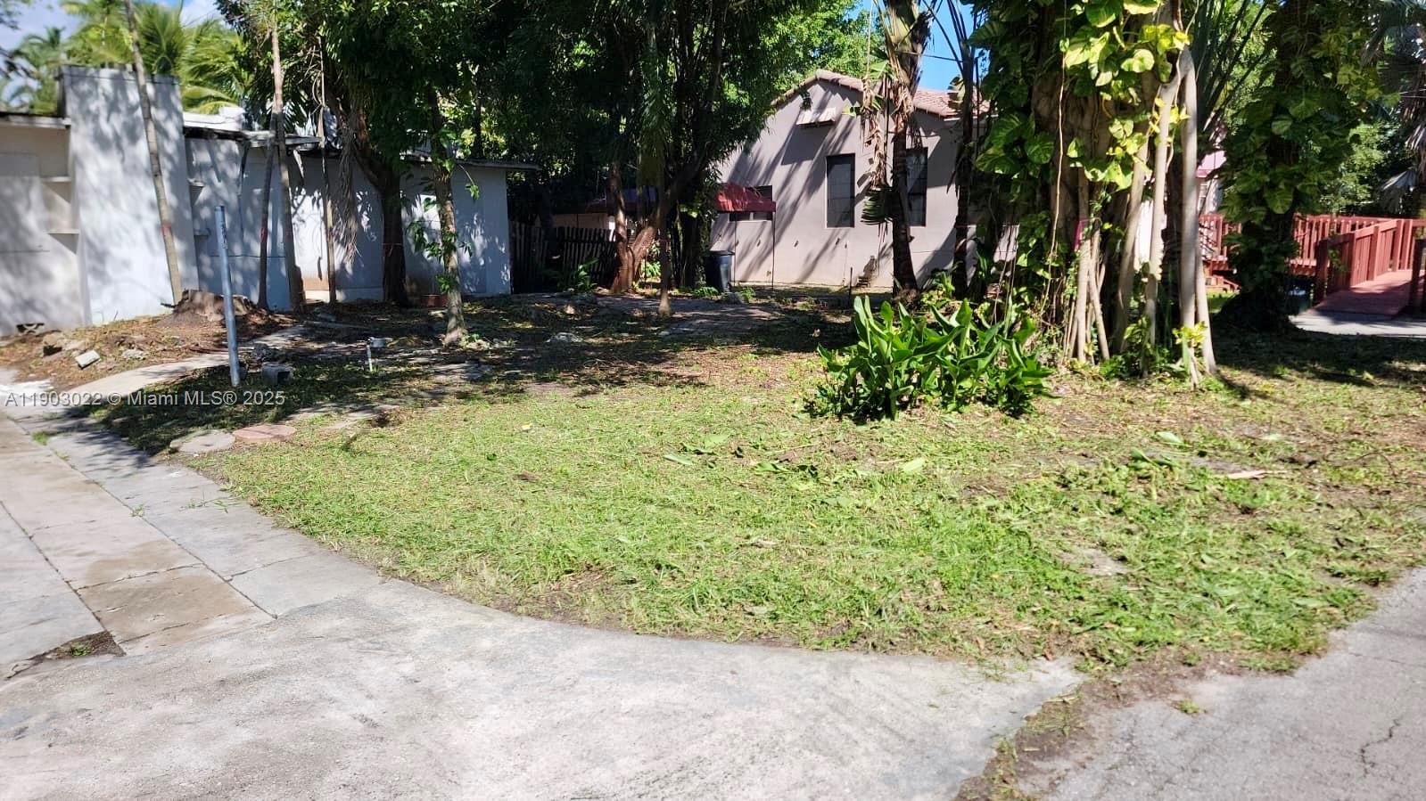 A grassy yard with trees and a house in the background — 519 NE 118th St, Biscayne Park FL 33161, BISCAYNE PARK, FL