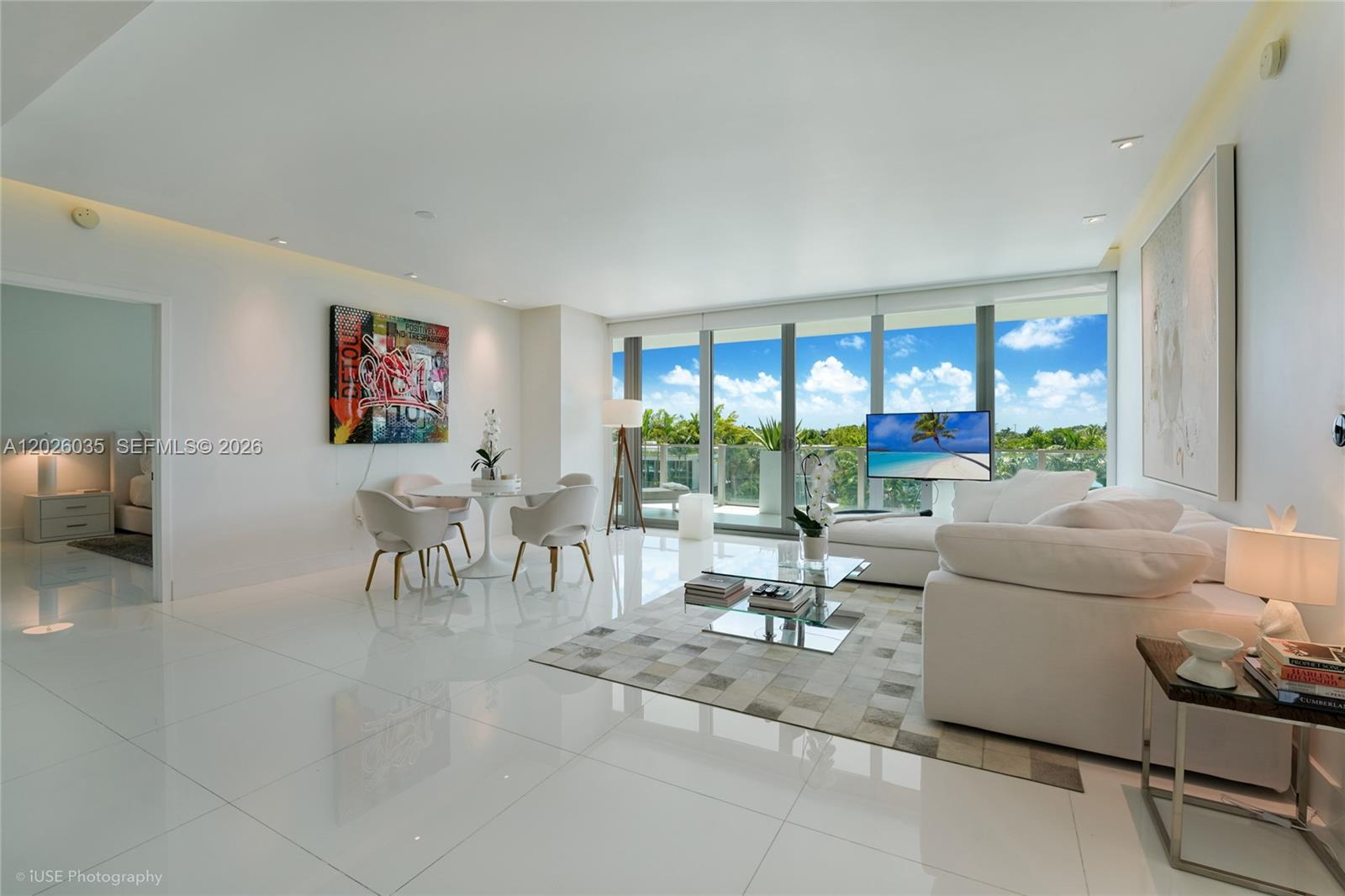 A bright living and dining area features white tile floors, modern furniture, and floor-to-ceiling windows — 350 Ocean Dr # 405N, Key Biscayne FL 33149, KEY BISCAYNE, FL
