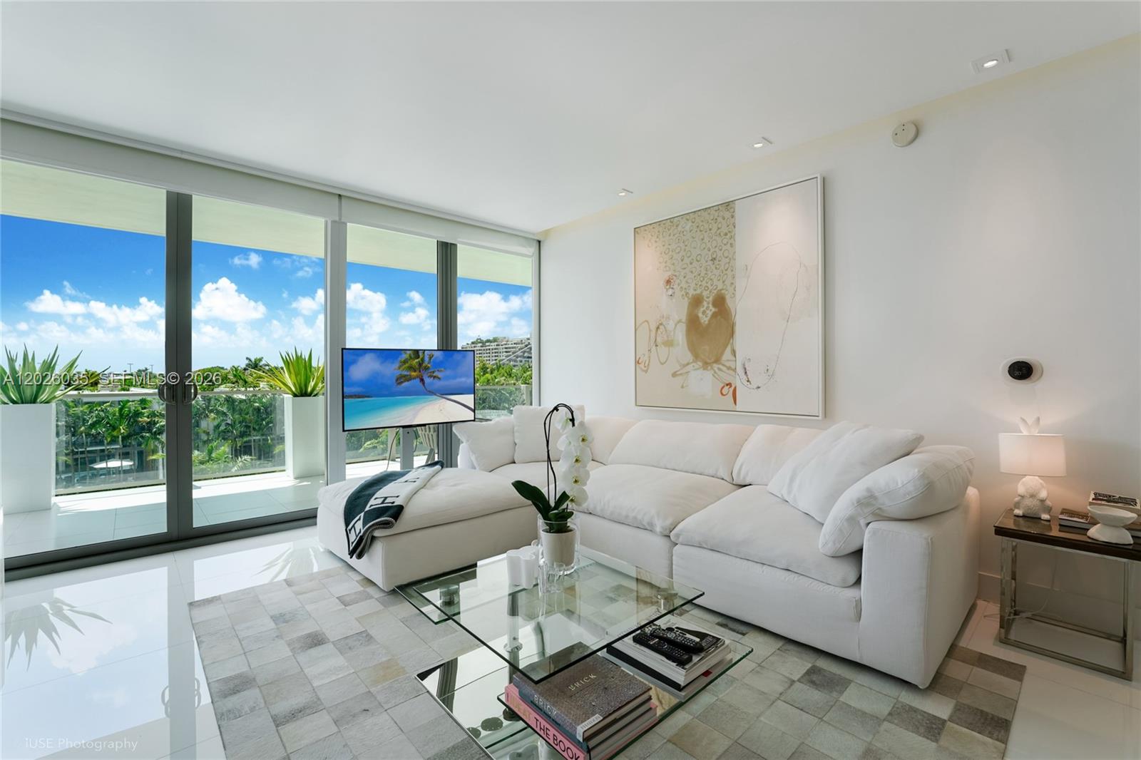 A modern living room features a white sectional sofa, glass coffee table, and floor-to-ceiling windows — 350 Ocean Dr # 405N, Key Biscayne FL 33149, KEY BISCAYNE, FL