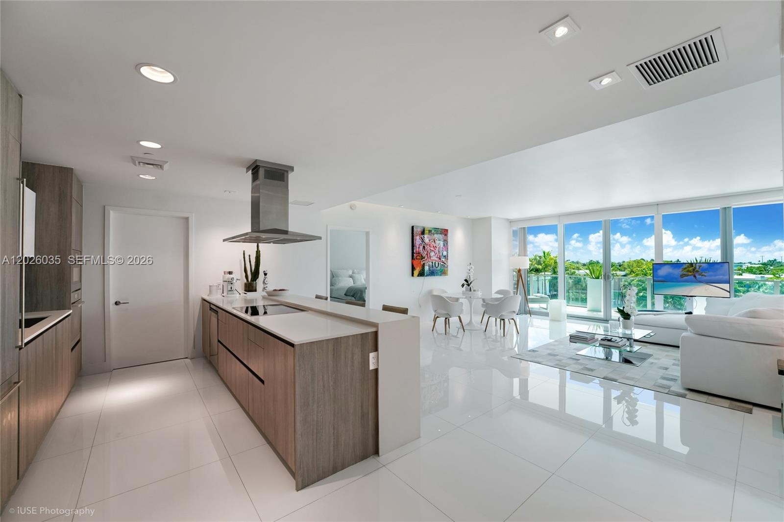 A modern open-concept kitchen and living area features white tile floors and floor-to-ceiling windows — 350 Ocean Dr # 405N, Key Biscayne FL 33149, KEY BISCAYNE, FL