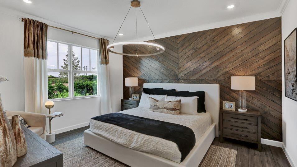 A bedroom features a chevron-patterned wood accent wall, a modern ring chandelier, and white bedding — 19780 Whispering Creek Road, FL 33470, FL