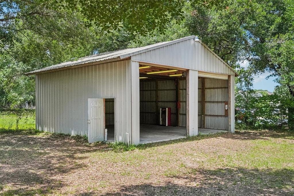 A detached metal garage with two open bays and a side entry door — 126 S SAINT CLOUD AVENUE, VALRICO, FL