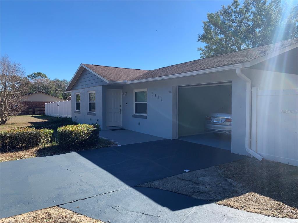 A single-story house with a gray exterior, a front-facing garage, and a paved driveway — 3536 EAGLES NEST ROAD, FRUITLAND PARK, FL