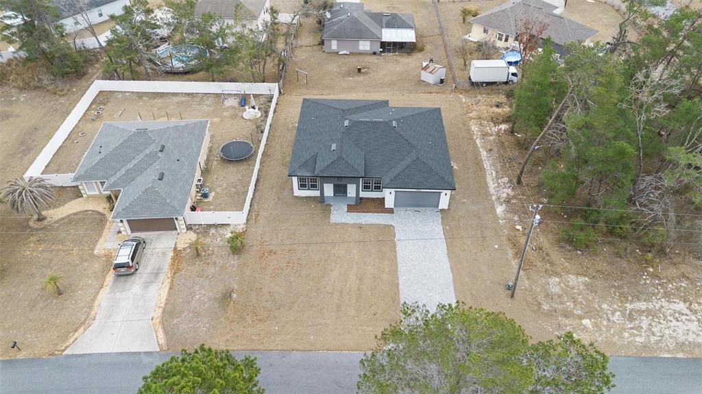 An aerial view shows two adjacent houses with driveways, fenced yards, and surrounding wooded areas — 15303 SW 48TH AVENUE, OCALA, FL