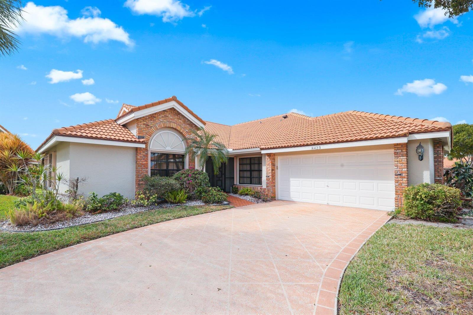 A single-story house with a brick facade, tile roof, and a patterned concrete driveway — 8423 Juddith Avenue, Boynton Beach FL 33472, BOYNTON BEACH, FL