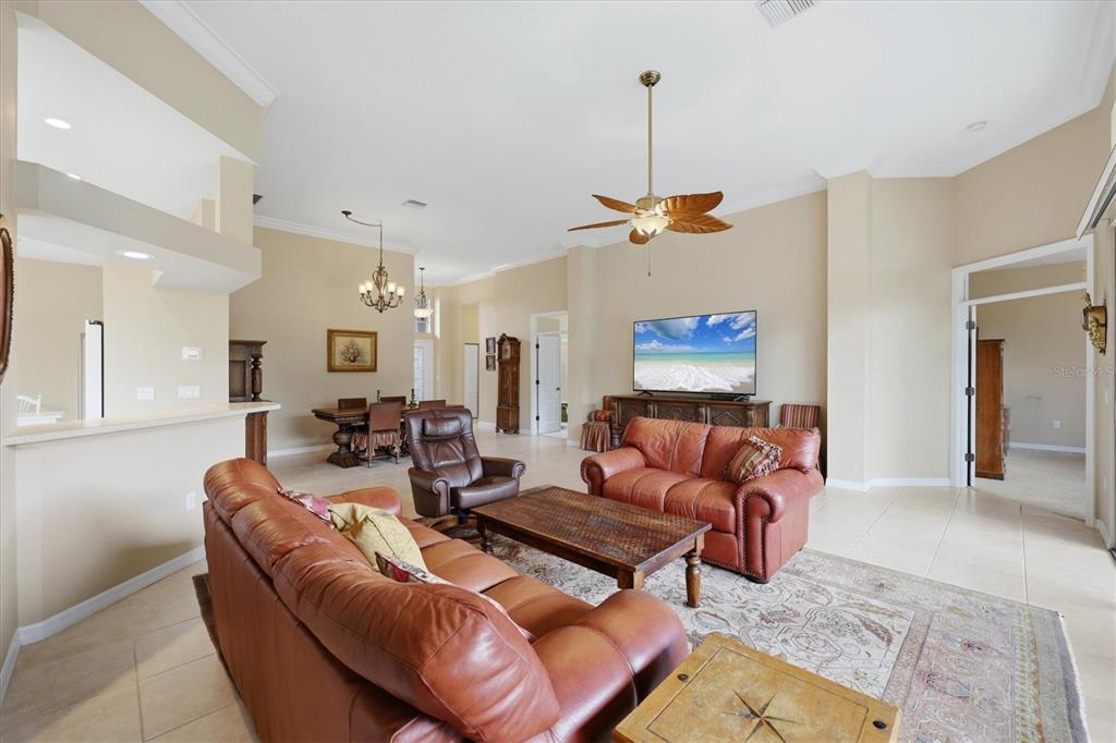 A living room with leather sofas, a coffee table, and a dining area in the background — 762 SILK OAK DRIVE, VENICE, FL