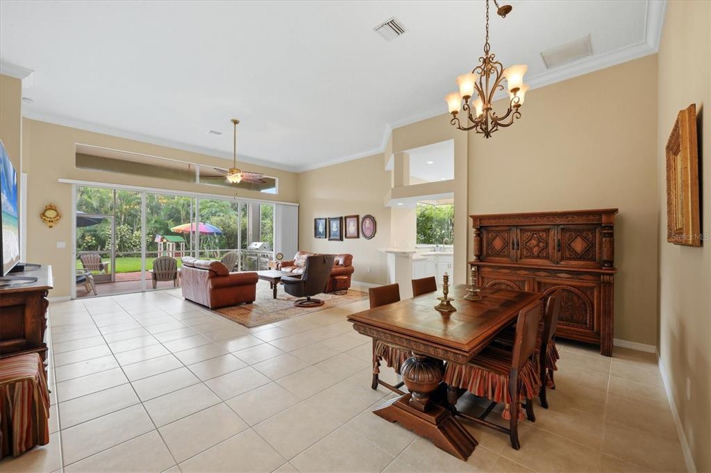 A kitchen with white cabinets, light countertops, tile flooring, and a corner window — 762 SILK OAK DRIVE, VENICE, FL