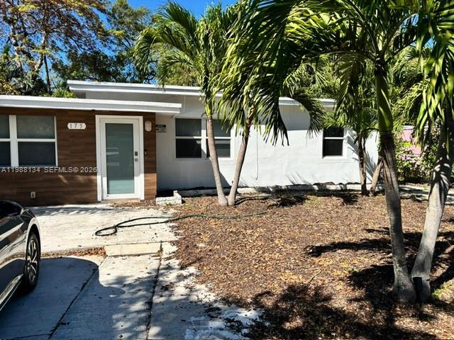 A single-story house with a white exterior, a glass front door, and surrounding palm trees — 175 NW 121st St, North Miami FL 33168, NORTH MIAMI, FL