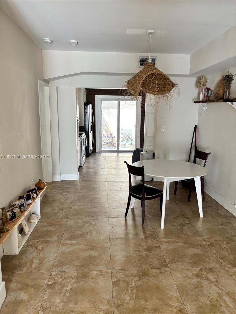 A dining area features a round white table, a textured pendant light, and tile flooring — 175 NW 121st St, North Miami FL 33168, NORTH MIAMI, FL