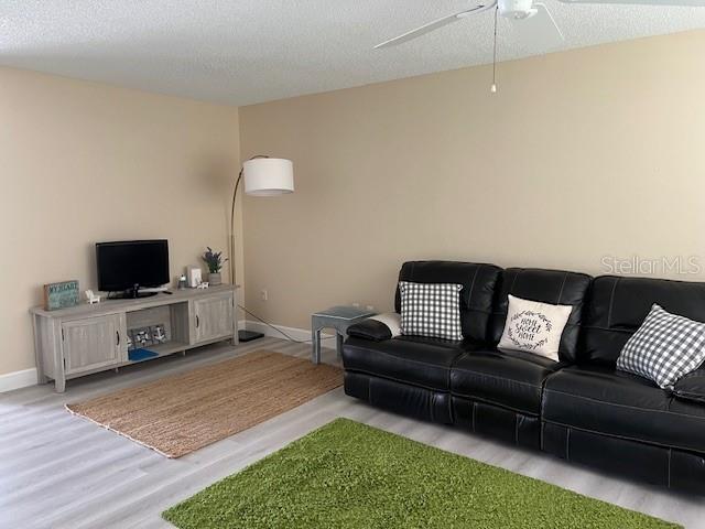 A living room features a black leather sofa, a gray media console, and two area rugs — 4192 GINGOLD STREET, PORT CHARLOTTE, FL