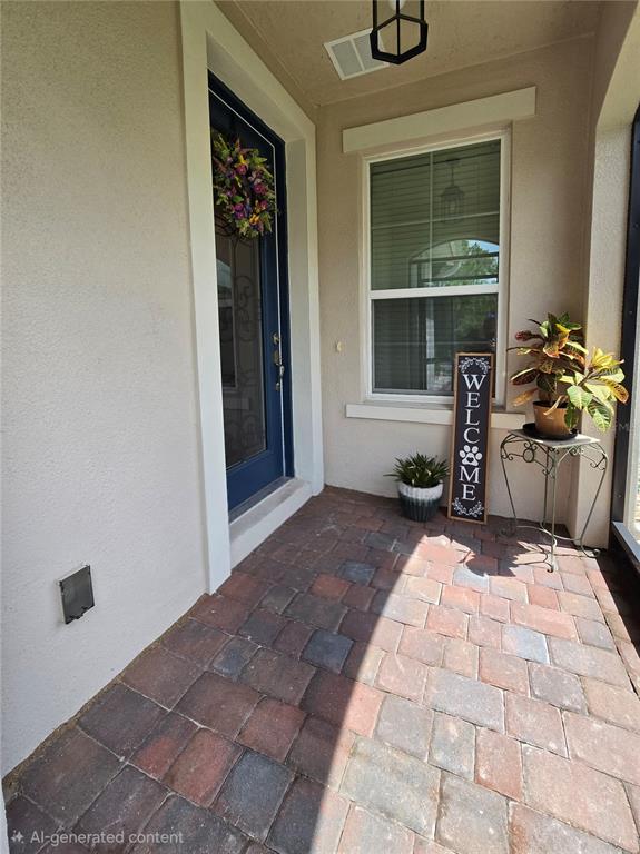 A covered entryway features a blue front door, a window, and a brick paver floor — 373 VESTRELLA DRIVE, POINCIANA, FL