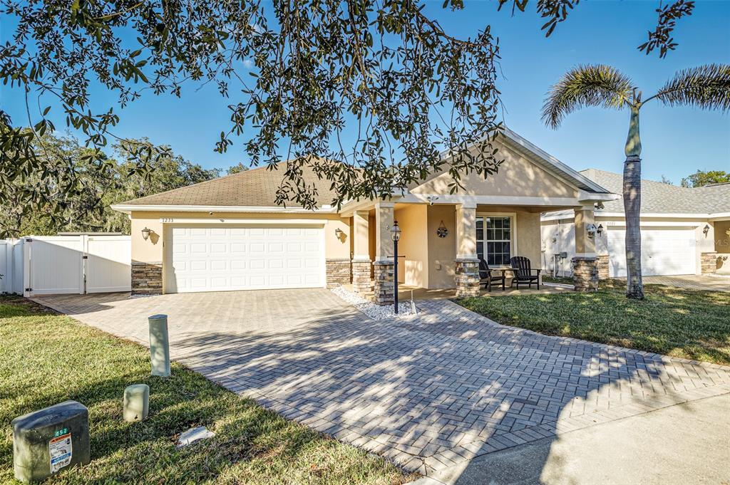 A single-story house with a paved driveway, white garage door, and a covered front porch — 7233 WAKEVIEW DRIVE, DAVENPORT, FL