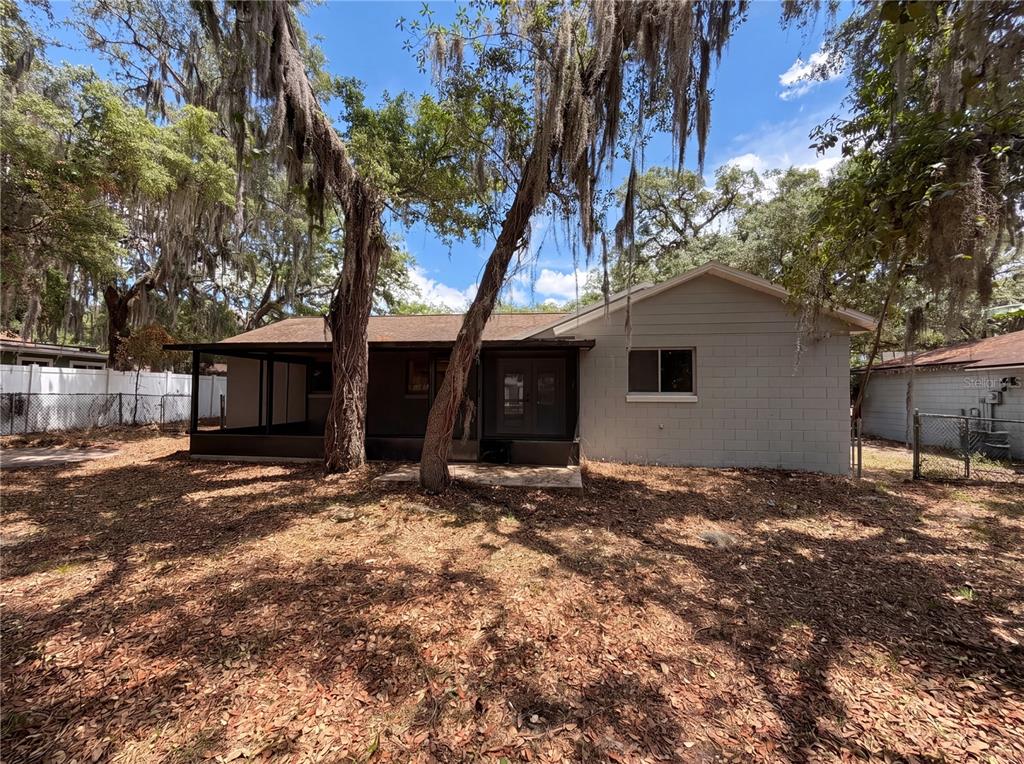 The exterior of a single-story house features a covered patio and a gray block wall — 2768 GALATIAN PLACE, ORLANDO, FL
