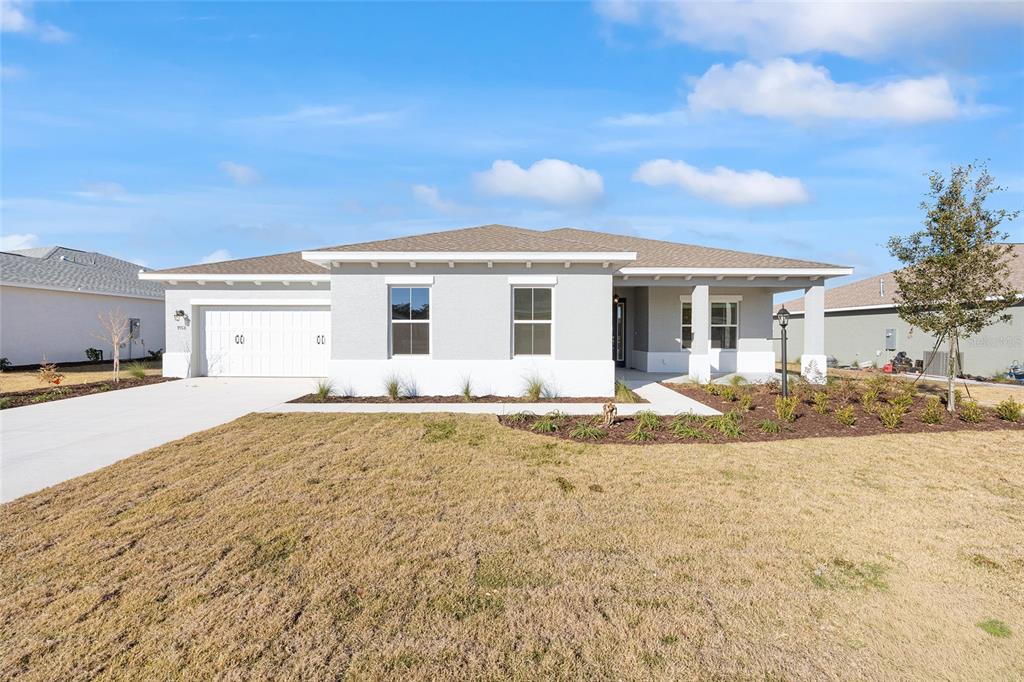 A single-story house with a white garage, gray exterior walls, and a front porch — 9918 SW 106TH CIRCLE, OCALA, FL