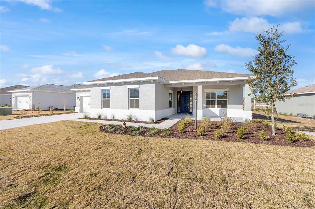 A single-story house with a light gray exterior, a covered entryway, and a front lawn — 9918 SW 106TH CIRCLE, OCALA, FL