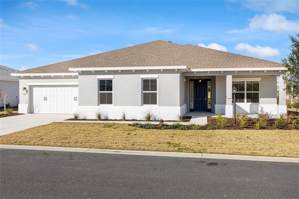 A single-story house with a gray stucco exterior, a two-car garage, and a covered entryway — 9918 SW 106TH CIRCLE, OCALA, FL