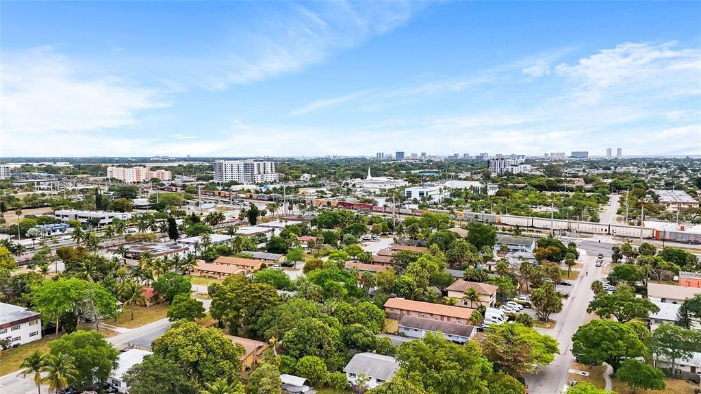 An aerial view shows a residential neighborhood with lush trees and a nearby train track — 330 SW Avondale Drive, Pompano Beach FL 33060, POMPANO BEACH, FL