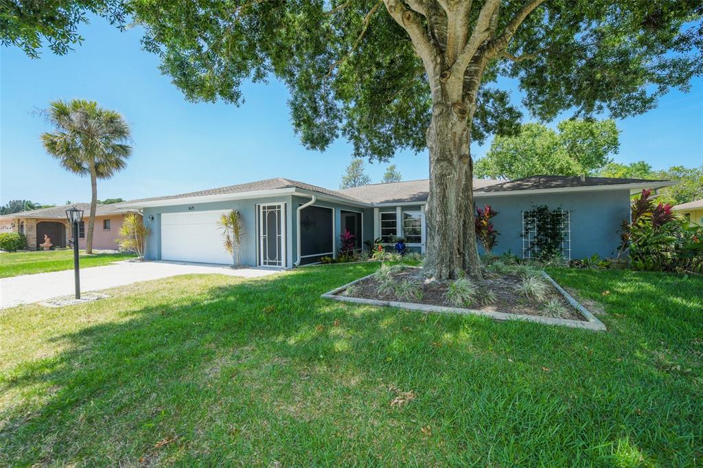 A single-story house with a gray exterior, a two-car garage, and a large front tree — 1625 BAY HILL CIRCLE, SARASOTA, FL