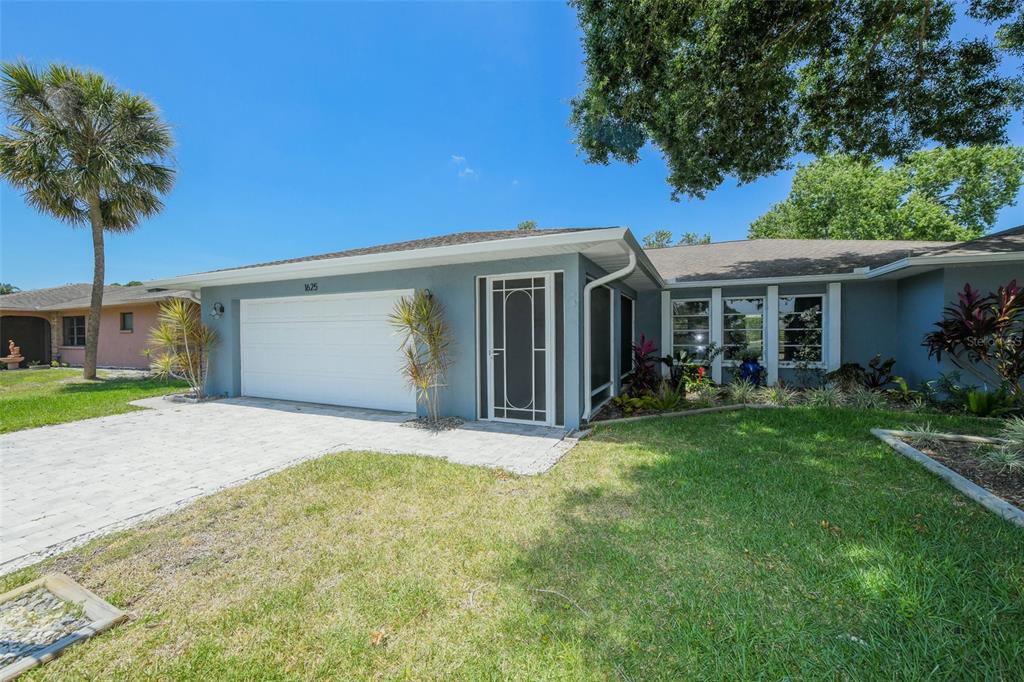 A single-story house with a blue exterior, a white garage door, and a screened front entryway — 1625 BAY HILL CIRCLE, SARASOTA, FL