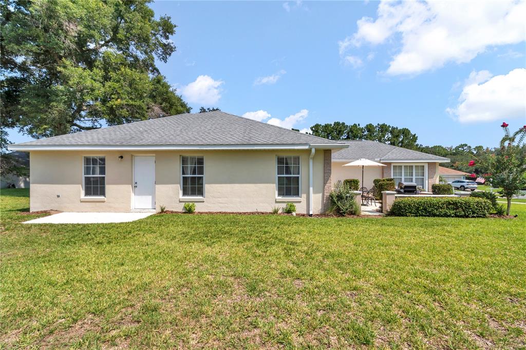 The exterior view shows a single-story house with a beige stucco facade and a patio — 7229 SW 115TH PLACE, OCALA, FL