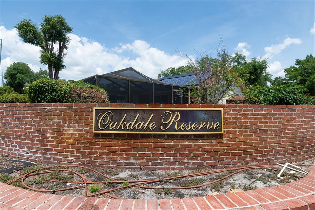 A brick wall with a sign reading Oakdale Reserve sits in front of a house — 4704 LIGHTERWOOD WAY, VALRICO, FL