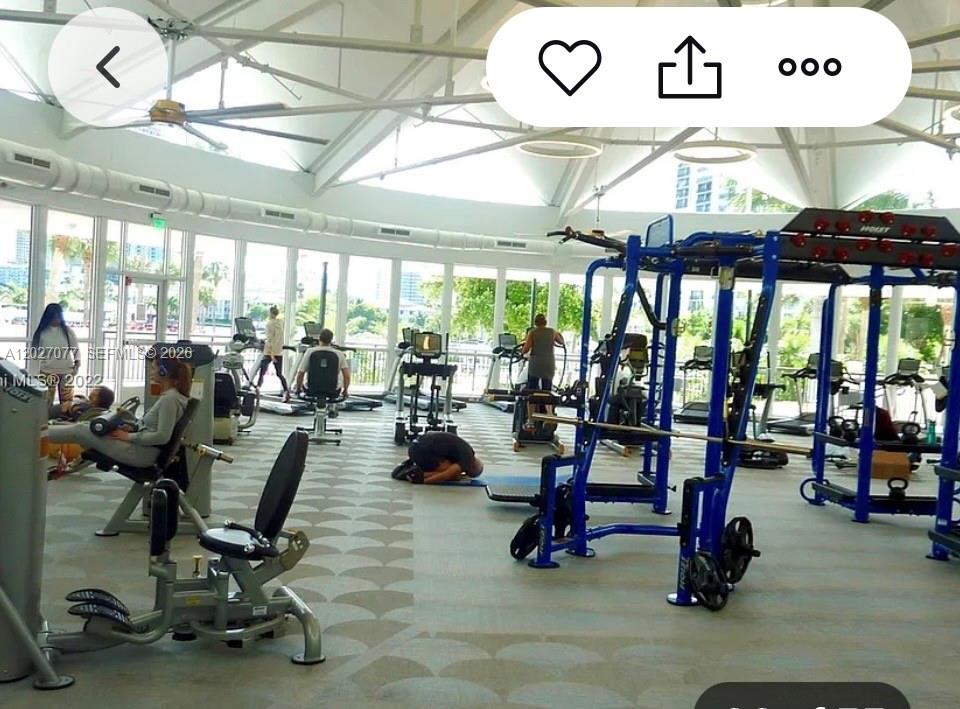 A bright gym with floor-to-ceiling windows, exercise machines, and a high, vaulted ceiling — 600 Three Islands Blvd # 312, Hallandale Beach FL 33009, HALLANDALE BEACH, FL