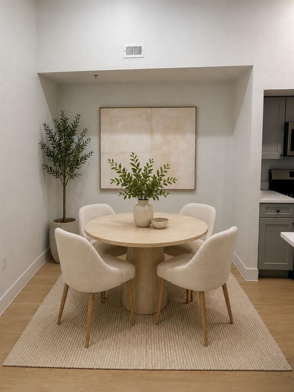 A dining area features a round table with four chairs on a textured rug — 13016 PLANTATION PARK CIRCLE UNIT 1131, ORLANDO, FL