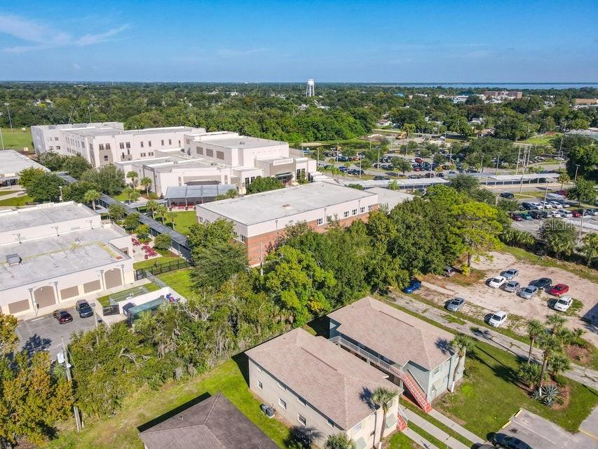 An aerial view shows a large school building complex adjacent to residential apartment buildings — 714 MICHIGAN COURT UNIT 1, 2, 3 and 4, ST CLOUD, FL