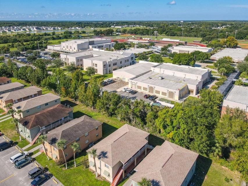 An aerial view shows multi-story residential buildings adjacent to a large commercial or school complex — 714 MICHIGAN COURT UNIT 1, 2, 3 and 4, ST CLOUD, FL