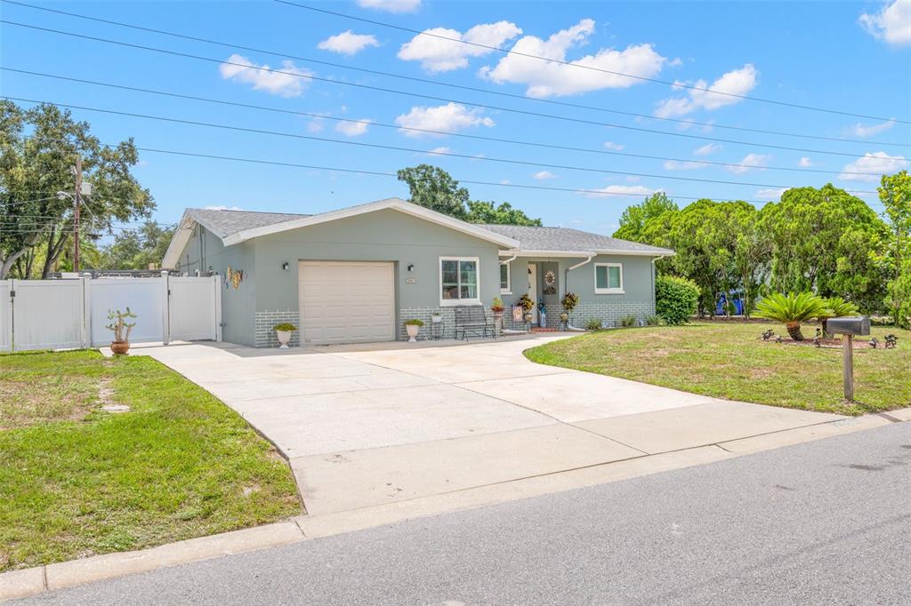 A single-story house with a light green exterior, a one-car garage, and a concrete driveway — 29861 69TH STREET N, CLEARWATER, FL