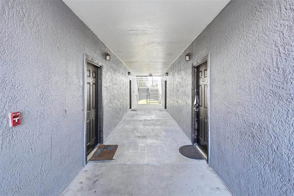 A living room features gray walls, a wood media console, a sofa, and a balcony — 5526 PGA BOULEVARD UNIT 4927, ORLANDO, FL