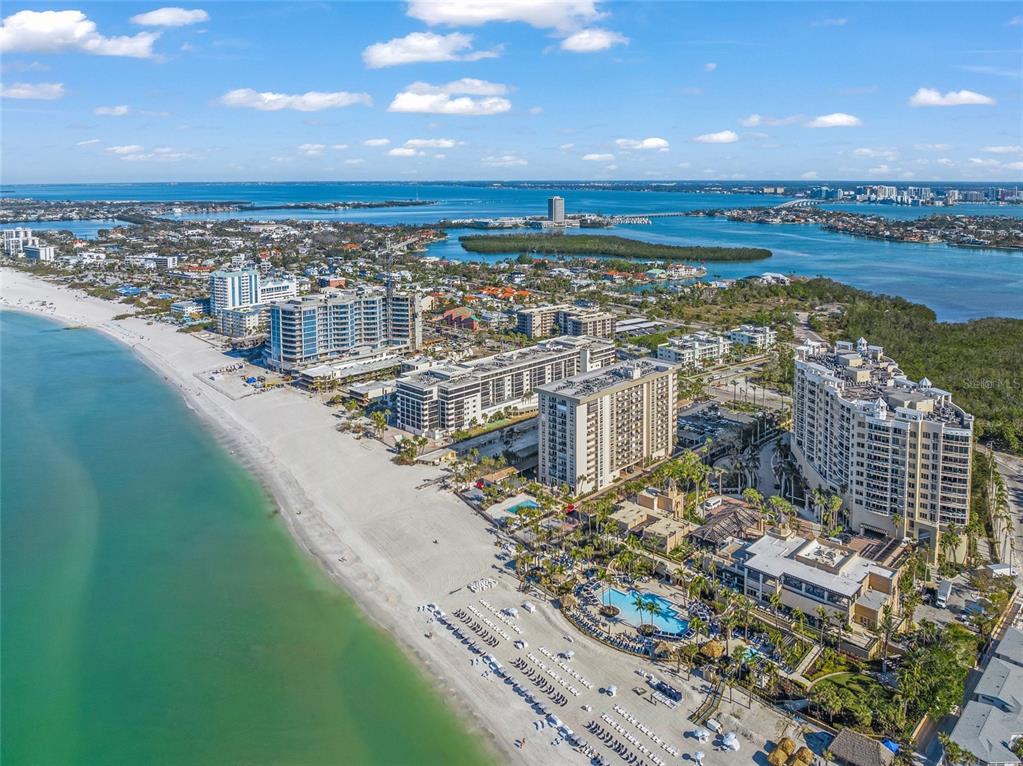 An aerial view of a sandy beach lined with high-rise hotels and resort buildings — 1212 BENJAMIN FRANKLIN DRIVE UNIT 102, SARASOTA, FL