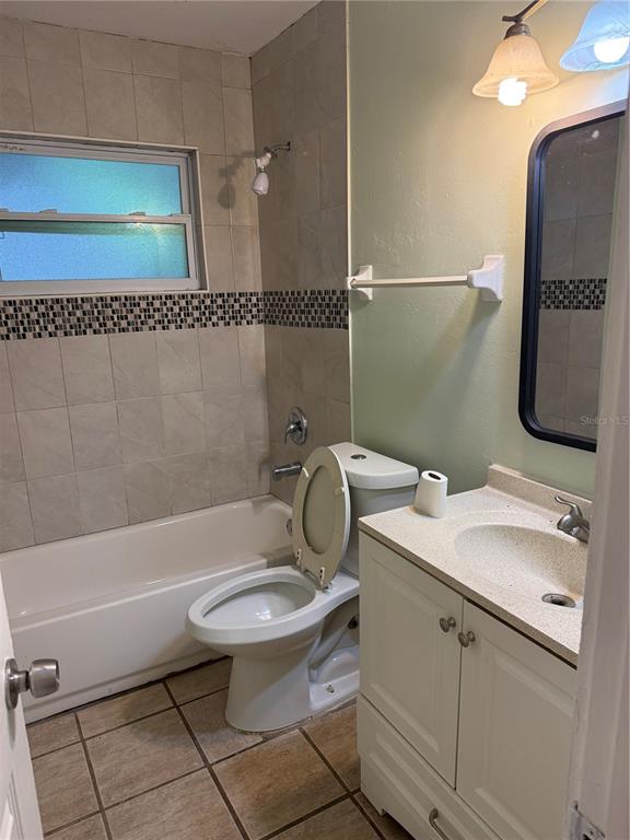 A bathroom features a tiled tub-shower combo, a white vanity, and a toilet — 3543 BALI DRIVE, SARASOTA, FL