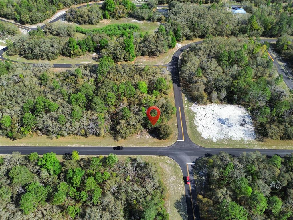 An aerial view shows a wooded corner lot marked with a red pin near roads — TBD SW 146TH LANE ROAD, OCALA, FL