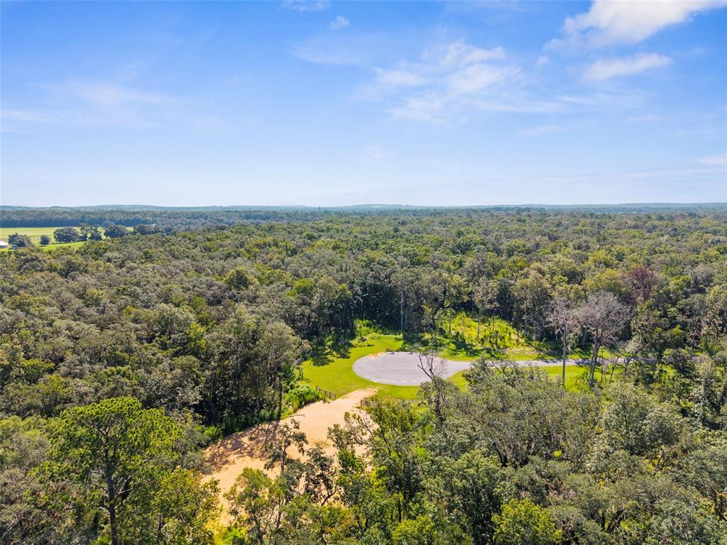 An aerial view shows a paved cul-de-sac surrounded by dense forest and a dirt driveway — REPUBLICAN (LOT 6) WAY, BROOKSVILLE, FL