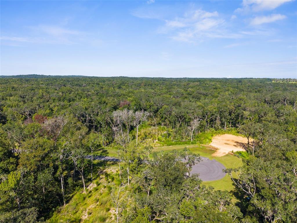 An aerial view shows a paved cul-de-sac surrounded by dense forest and a sandy clearing — REPUBLICAN (LOT 6) WAY, BROOKSVILLE, FL