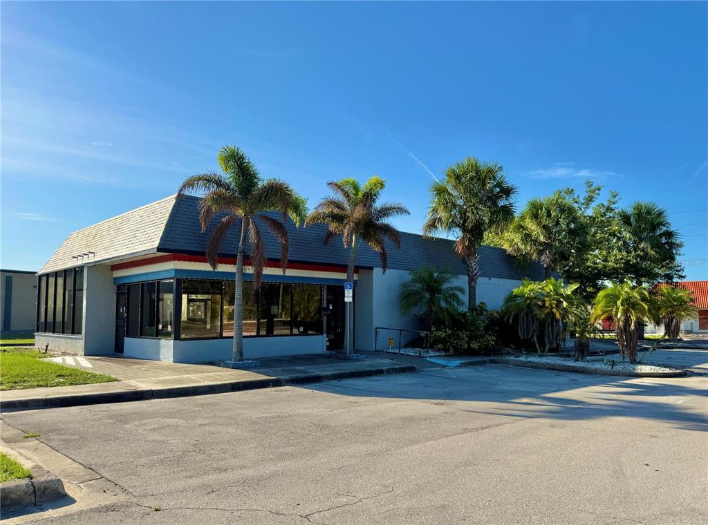 A single-story commercial building with a gray roof and palm trees in the front — 1520 LAKEVIEW DRIVE, SEBRING, FL