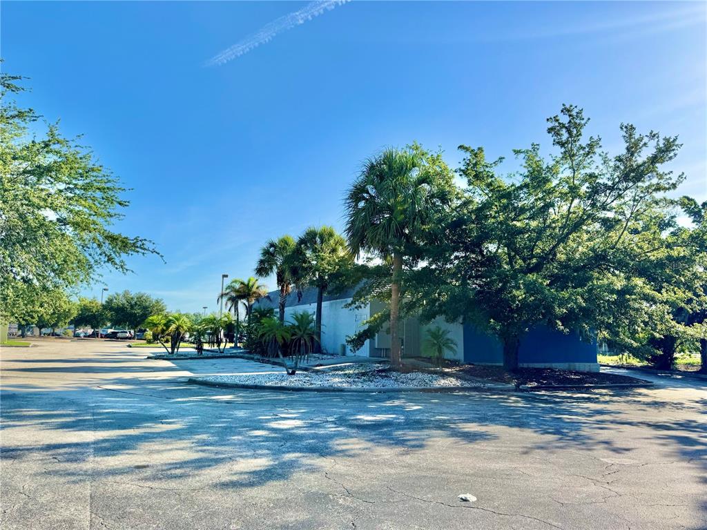 A single-story commercial building with a blue exterior is surrounded by trees and parking — 1520 LAKEVIEW DRIVE, SEBRING, FL