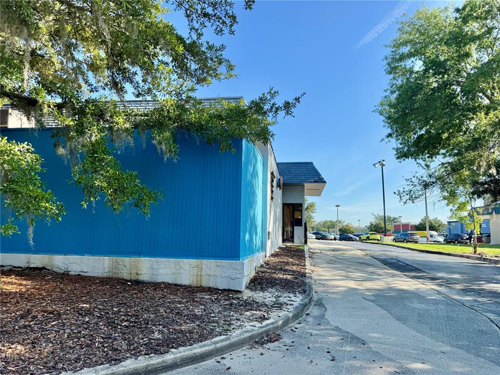 The exterior of a commercial building features a bright blue wall and a drive-thru window — 1520 LAKEVIEW DRIVE, SEBRING, FL