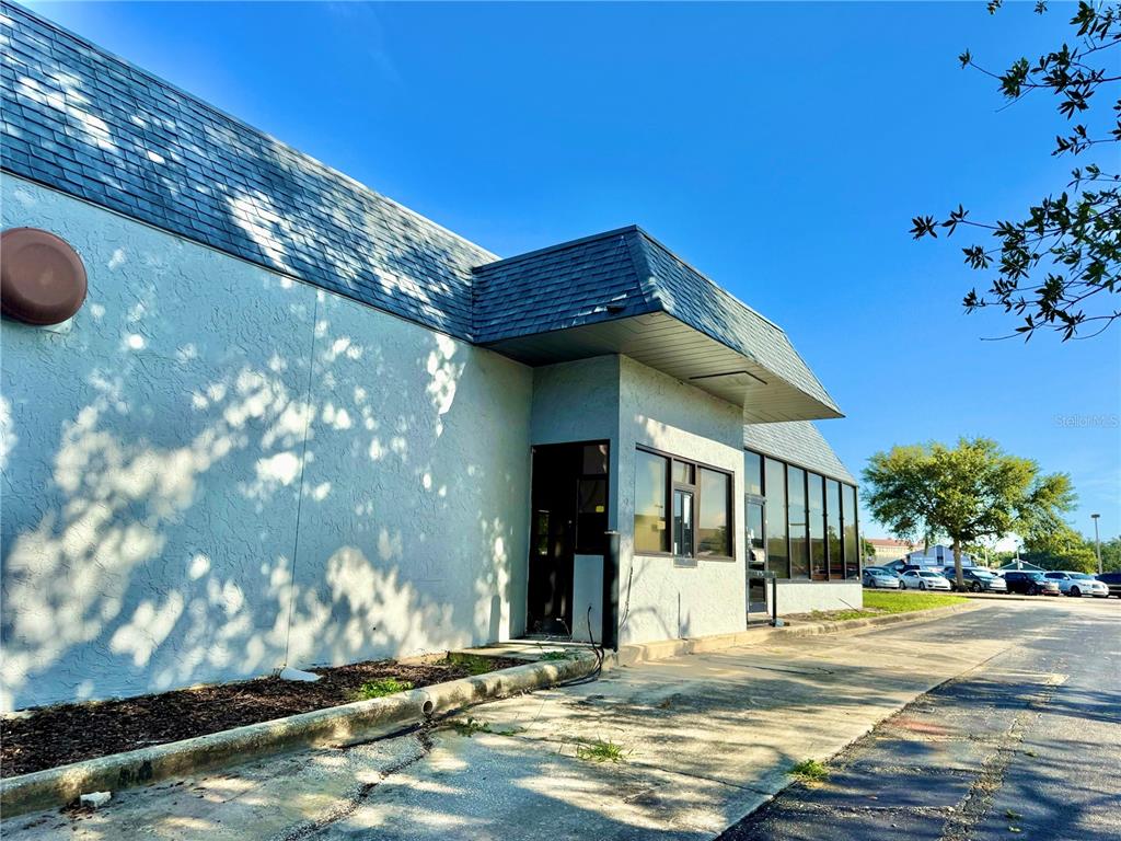 The exterior of a commercial building features a drive-thru window and a dark shingled roof — 1520 LAKEVIEW DRIVE, SEBRING, FL