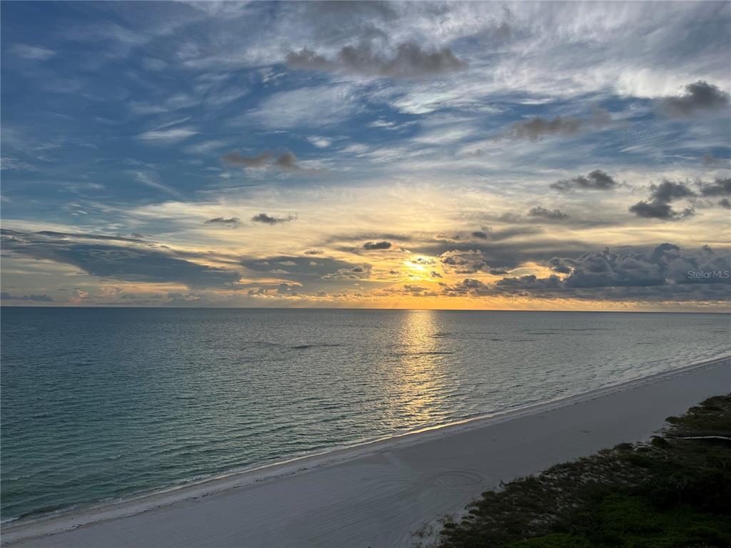 A high-angle view of a sandy beach and ocean at sunset under a cloudy sky — 775 LONGBOAT CLUB ROAD UNIT 401, LONGBOAT KEY, FL