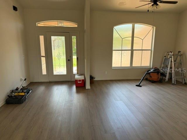 An empty room with light wood-look flooring, a front door, and a large arched window — 2576 TRIANNA STREET, NORTH PORT, FL
