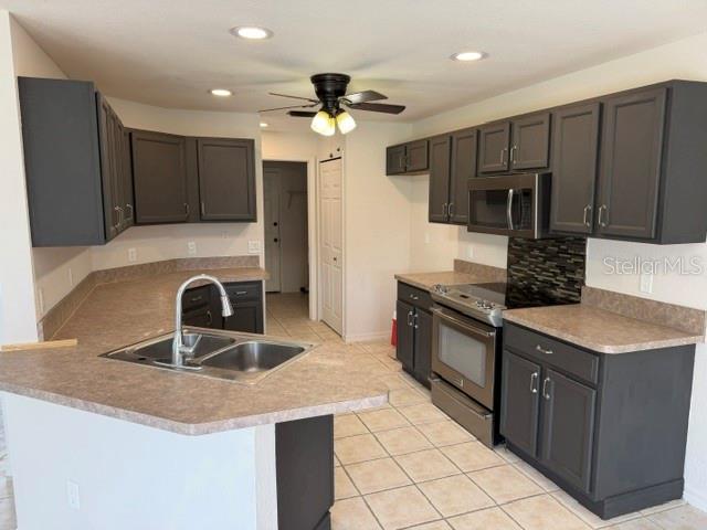 A kitchen features dark gray cabinets, laminate countertops, stainless steel appliances, and tile flooring — 2576 TRIANNA STREET, NORTH PORT, FL