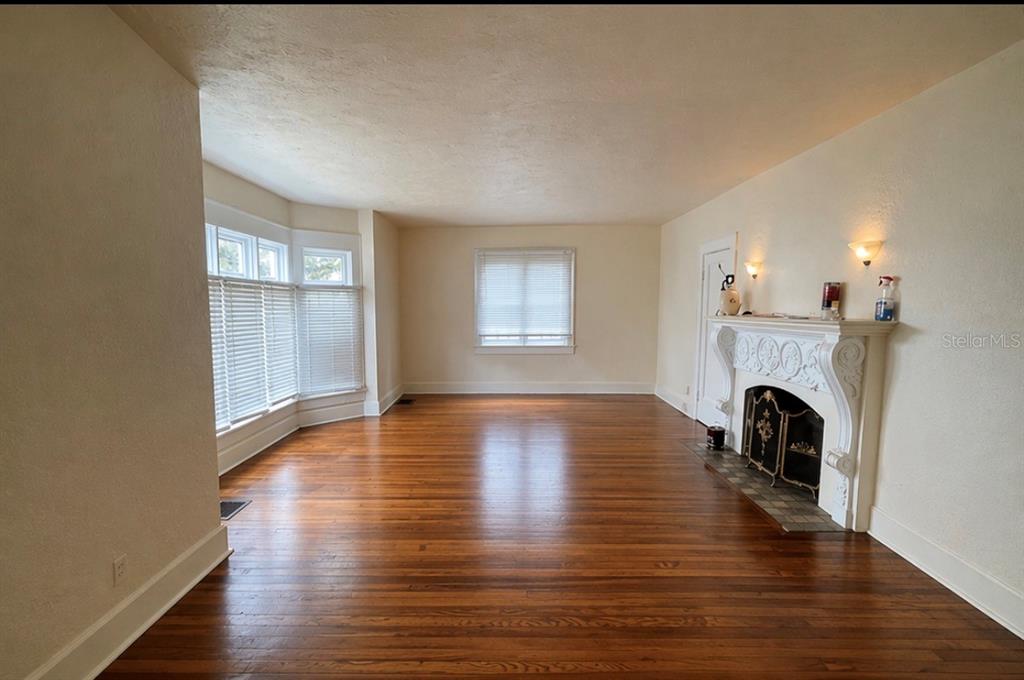 A living room with hardwood floors, a fireplace, and a bay window with white blinds — 1225 11TH STREET N, ST PETERSBURG, FL
