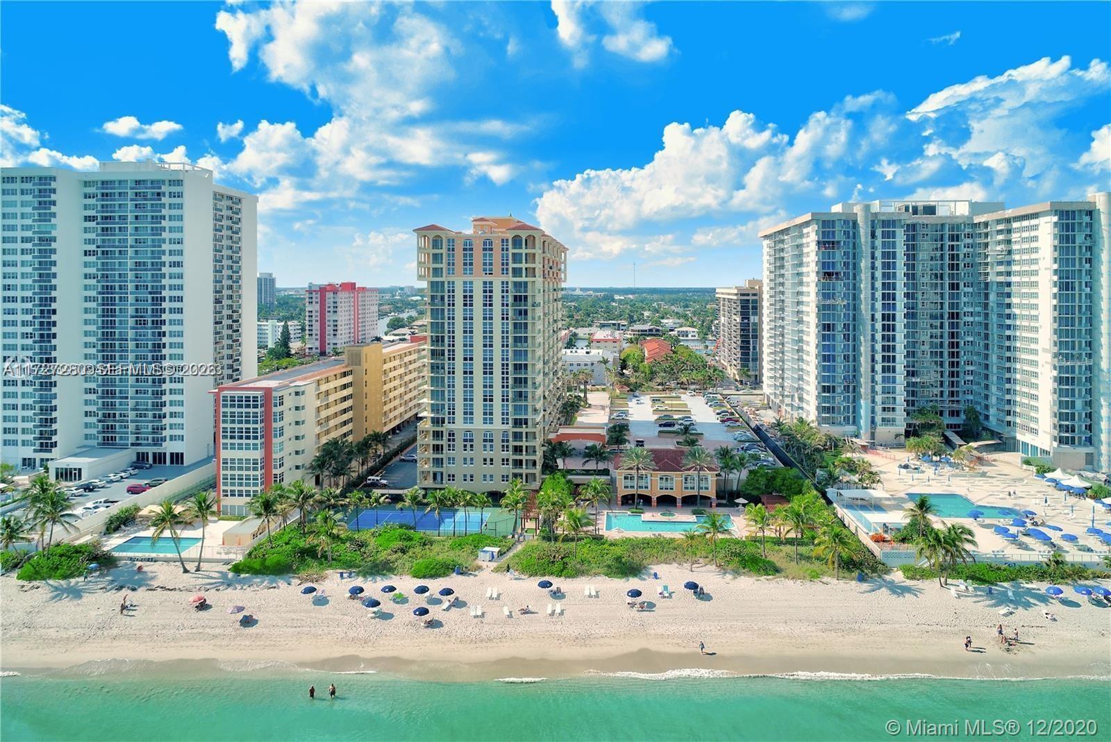 An aerial view shows high-rise residential buildings situated directly along a sandy beach — 2080 S Ocean Dr # 502, Hallandale Beach FL 33009, HALLANDALE BEACH, FL
